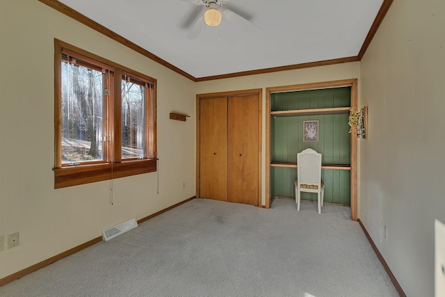 unfurnished bedroom with visible vents, carpet floors, baseboards, and ornamental molding