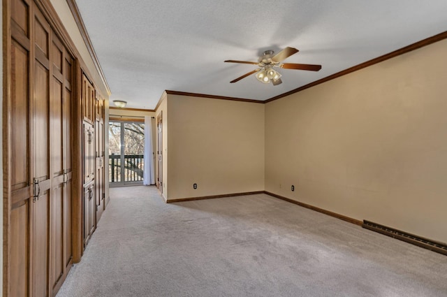 unfurnished room with a ceiling fan, baseboards, a textured ceiling, crown molding, and light carpet