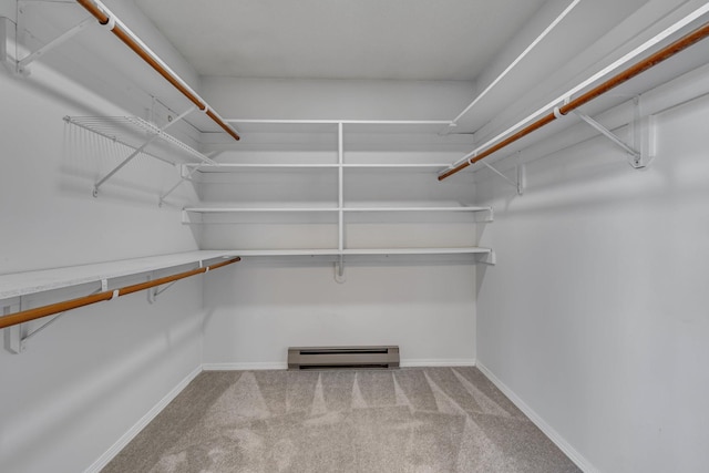 walk in closet featuring a baseboard heating unit and carpet flooring