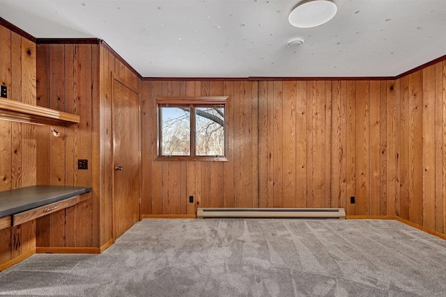 carpeted spare room featuring baseboards, baseboard heating, and wood walls