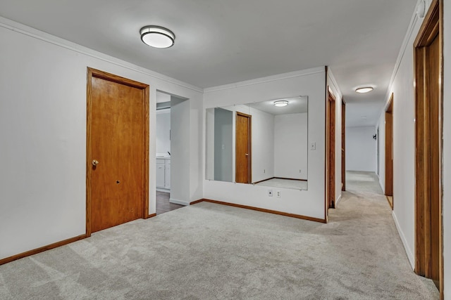 interior space featuring ensuite bath, baseboards, carpet floors, and ornamental molding