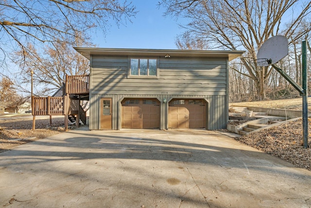 exterior space featuring a deck, concrete driveway, and an attached garage