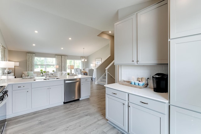 kitchen with tasteful backsplash, light countertops, lofted ceiling, stainless steel appliances, and a sink