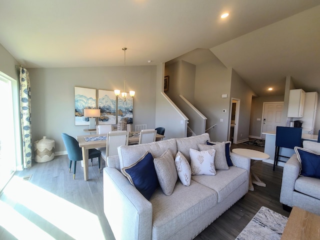 living area with wood finished floors, lofted ceiling, recessed lighting, stairs, and a chandelier