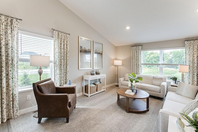 carpeted living area featuring lofted ceiling, a healthy amount of sunlight, and baseboards