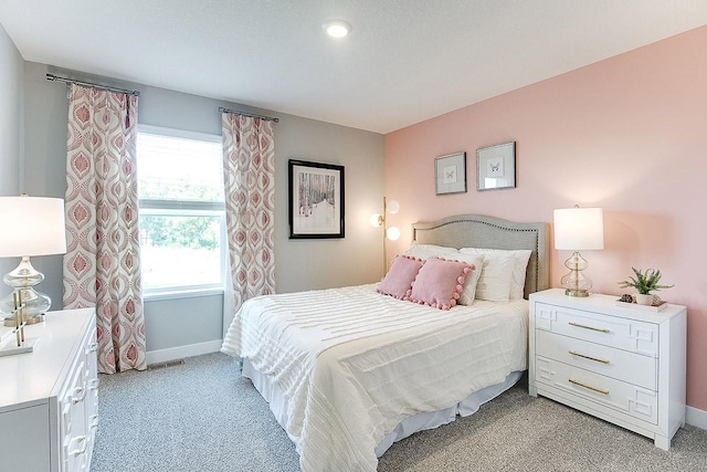 bedroom featuring light colored carpet and baseboards