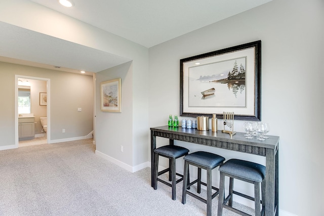 hallway featuring recessed lighting, an upstairs landing, baseboards, and light carpet