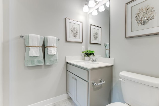 half bath featuring vanity, toilet, and baseboards