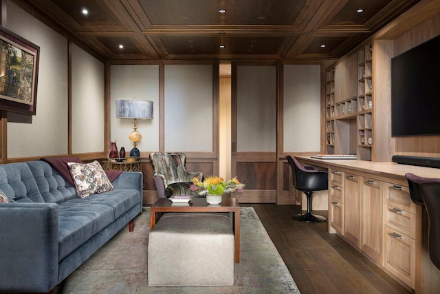 living room with beam ceiling, dark wood-type flooring, coffered ceiling, a decorative wall, and built in study area