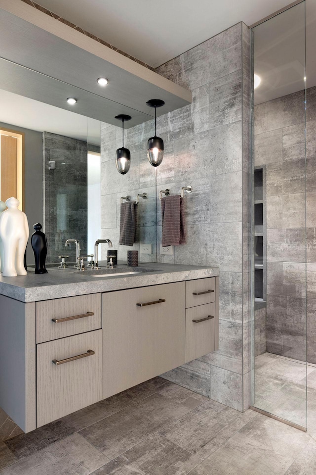 full bath featuring tiled shower and vanity