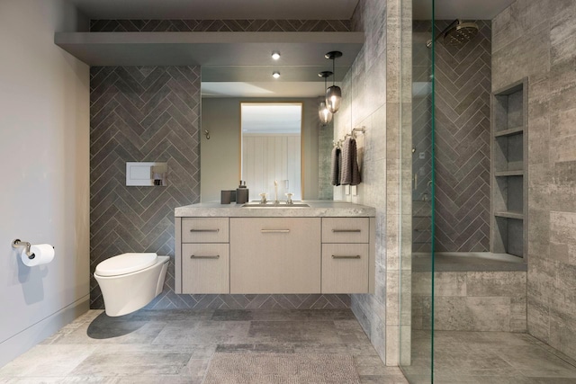 bathroom with tile walls, toilet, tiled shower, tile patterned floors, and vanity