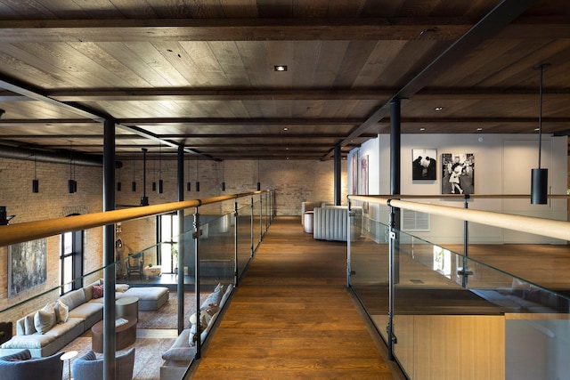 hallway featuring beamed ceiling, wooden ceiling, brick wall, and dark wood-style flooring