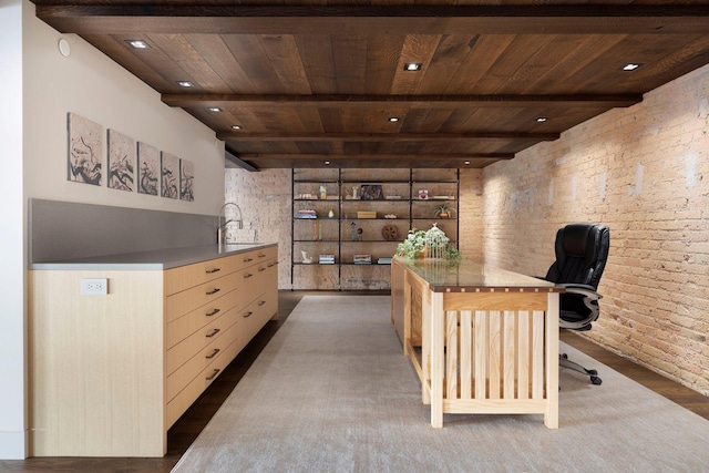 office featuring beamed ceiling, wood ceiling, brick wall, and a sink