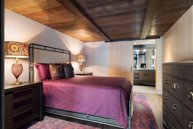 bedroom with ensuite bath, beamed ceiling, wood ceiling, and wood finished floors