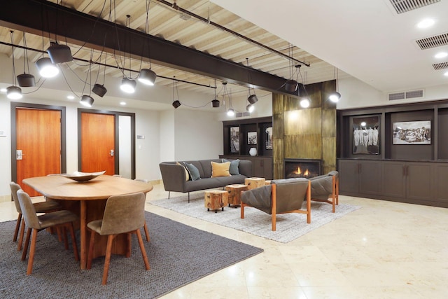 dining space with visible vents, beamed ceiling, and a fireplace