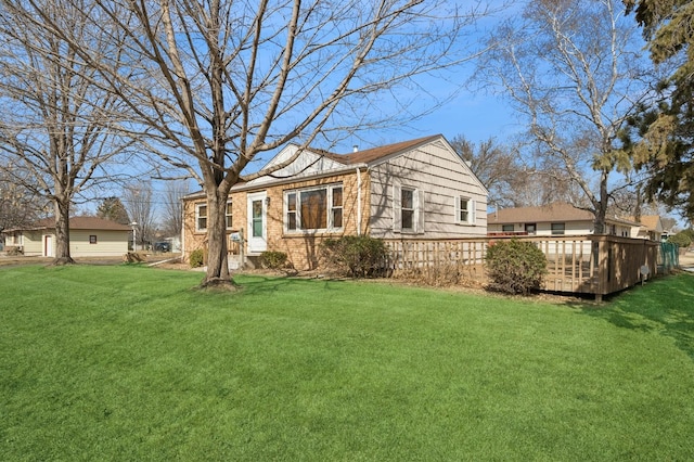 view of side of property featuring a wooden deck and a yard