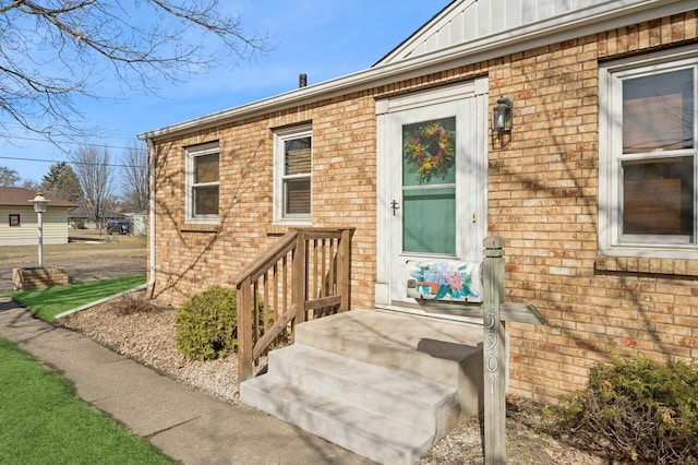 view of exterior entry featuring brick siding