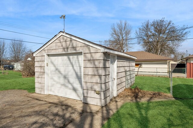 view of outbuilding featuring an outbuilding, fence, and driveway