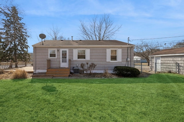 rear view of property with a lawn, cooling unit, and fence