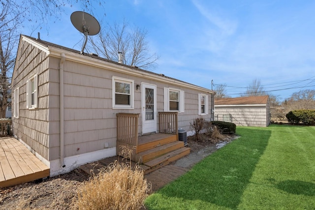 exterior space featuring central air condition unit, a wooden deck, and a front lawn