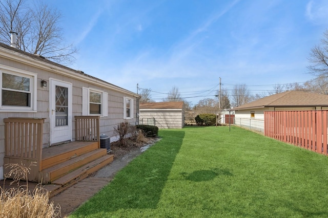 view of yard featuring fence and central AC