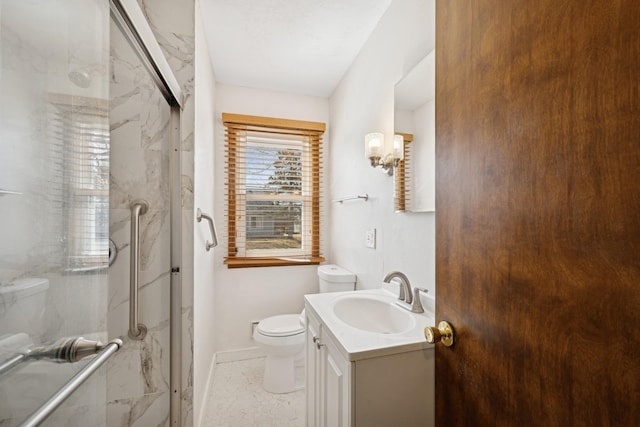 full bath featuring vanity, toilet, baseboards, and a marble finish shower