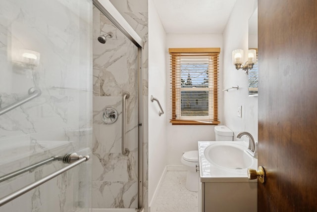 bathroom with vanity, toilet, baseboards, and a marble finish shower