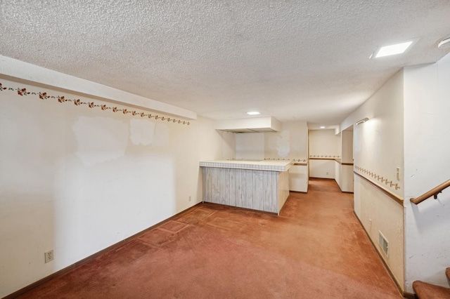 interior space featuring visible vents, light colored carpet, a textured ceiling, and stairs