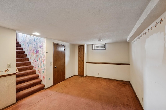 basement with carpet flooring, a textured ceiling, and stairs