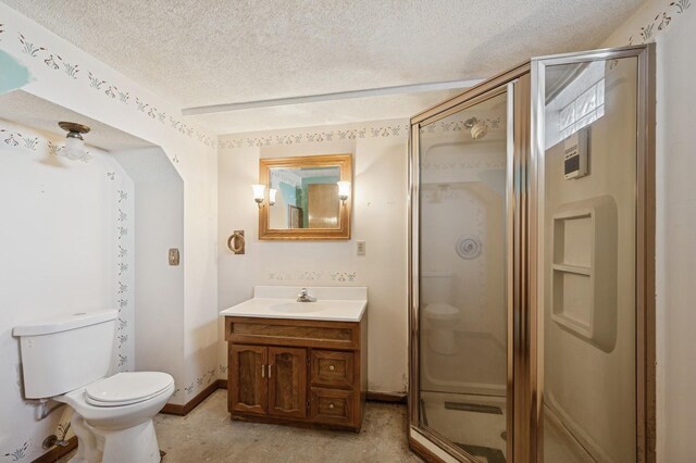 full bathroom with toilet, a textured ceiling, a shower stall, baseboards, and vanity