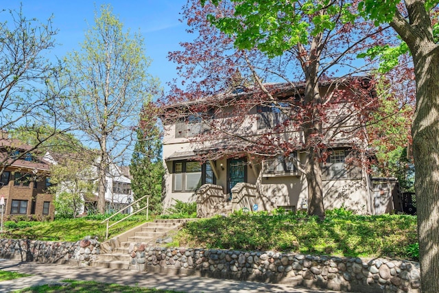 view of front of house featuring stairway and stucco siding