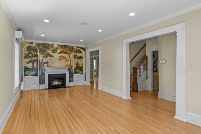 unfurnished living room with light wood-style flooring, crown molding, stairway, an AC wall unit, and a fireplace with flush hearth