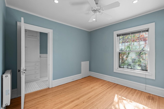unfurnished bedroom featuring ornamental molding, wood finished floors, recessed lighting, baseboards, and ensuite bath