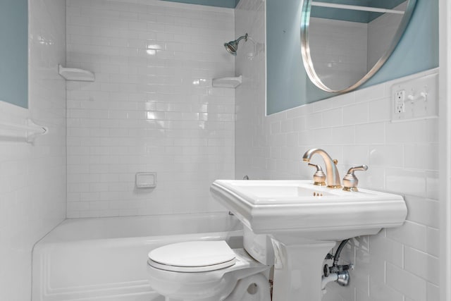 full bathroom featuring toilet,  shower combination, and tile walls
