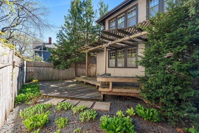 deck with a pergola and a fenced backyard