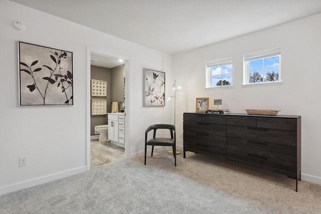 living area with light colored carpet and baseboards