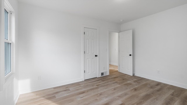 interior space featuring a closet, visible vents, baseboards, and wood finished floors