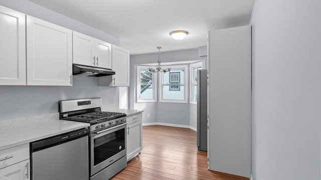 kitchen featuring dishwasher, under cabinet range hood, white cabinets, and stainless steel gas range