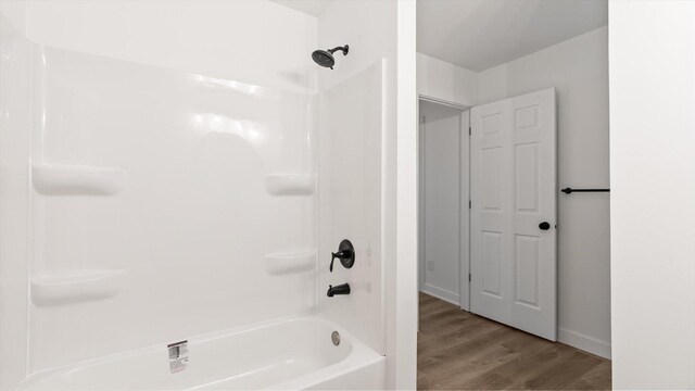 bathroom featuring wood finished floors and shower / washtub combination