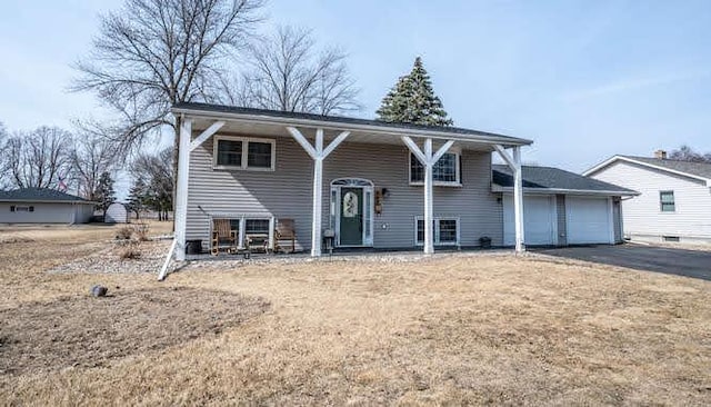 bi-level home featuring aphalt driveway and an attached garage