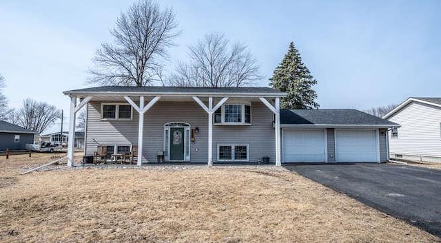 raised ranch with an attached garage and driveway