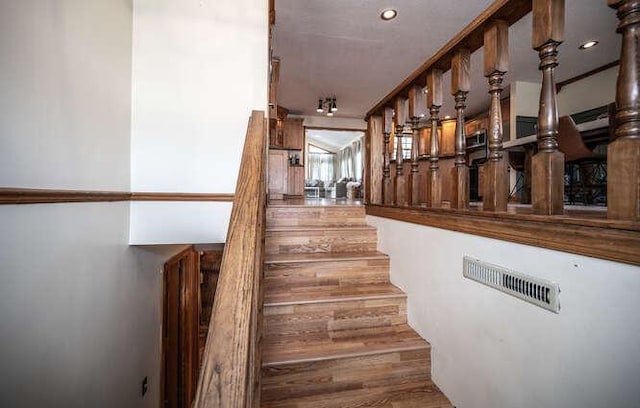 staircase featuring recessed lighting, visible vents, and wood finished floors