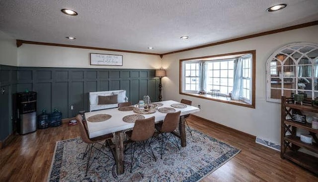 dining area with crown molding, recessed lighting, wood finished floors, and a textured ceiling