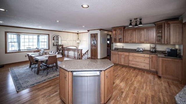 kitchen with a textured ceiling, wood finished floors, crown molding, glass insert cabinets, and dishwasher