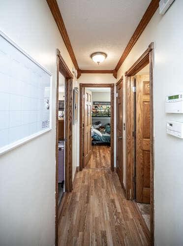 hall featuring wood finished floors and crown molding