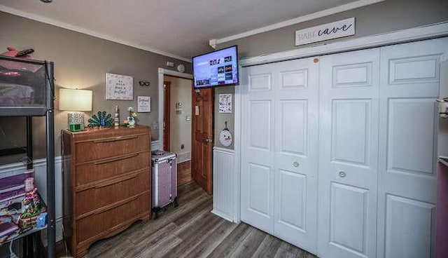 bedroom with a closet, wood finished floors, and ornamental molding