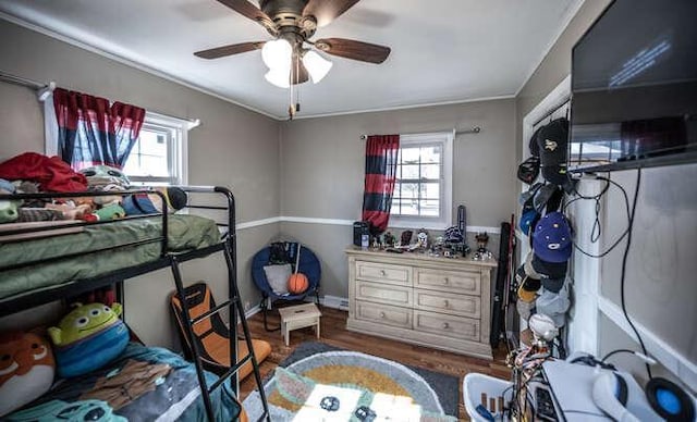 bedroom featuring a ceiling fan, multiple windows, and wood finished floors