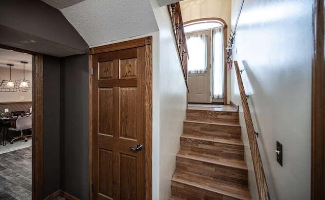 staircase with vaulted ceiling and wood finished floors