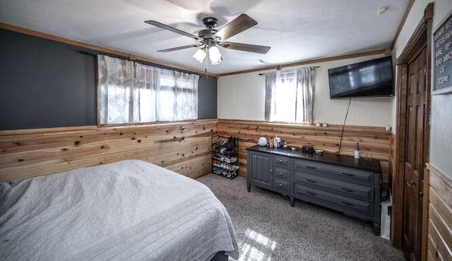 bedroom featuring a wainscoted wall, carpet, wooden walls, and crown molding