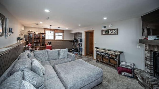 carpeted living room with recessed lighting and a brick fireplace